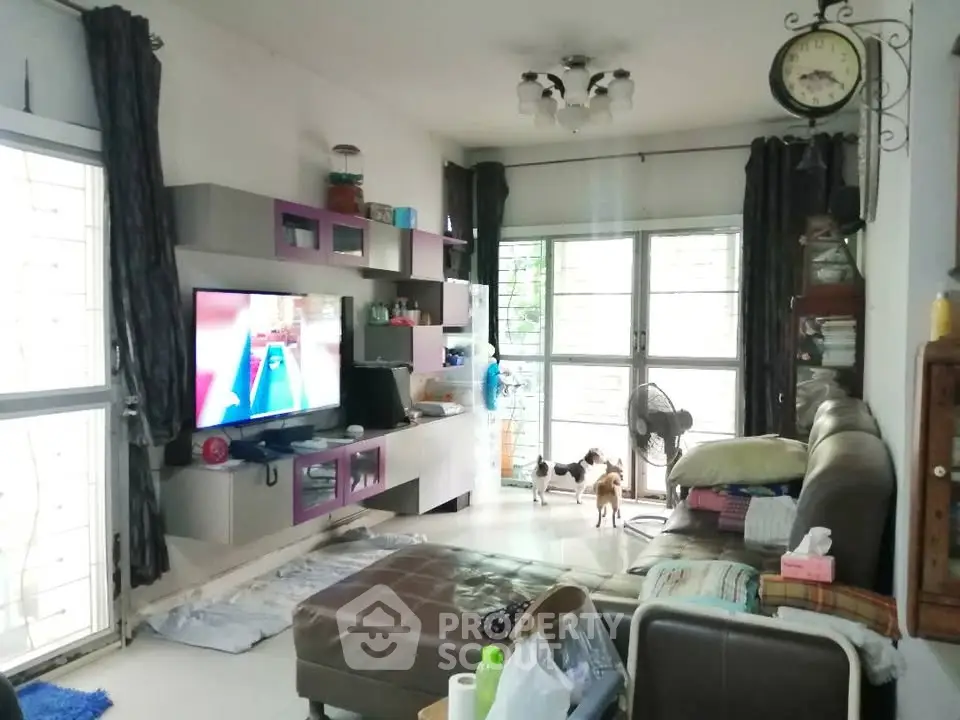 Spacious living room with modern entertainment center and large windows