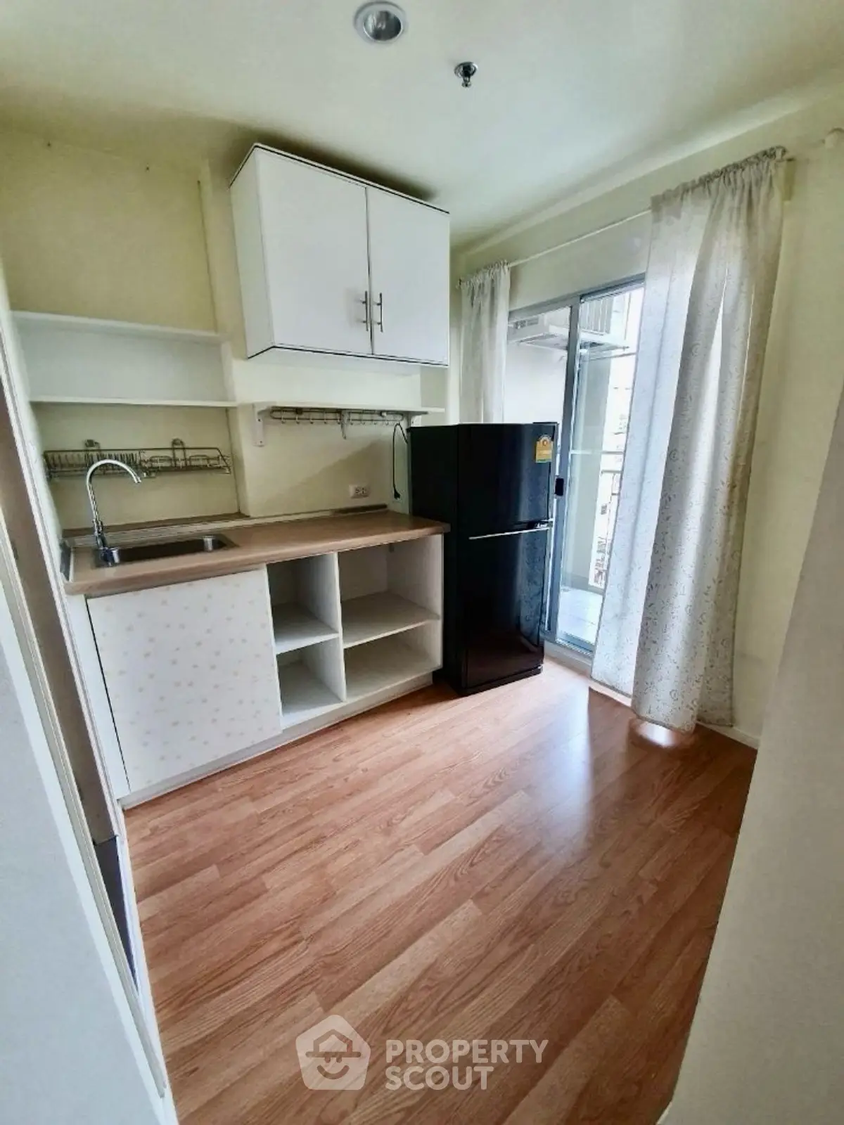 Cozy kitchen with wooden flooring and modern appliances, perfect for urban living.