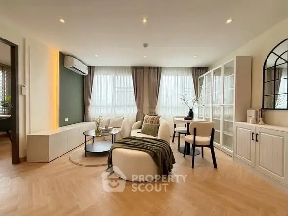 Elegant living room with modern furniture and large windows, featuring stylish decor and ample natural light.