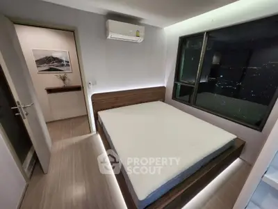 Modern bedroom with city view, featuring sleek design and ambient lighting.