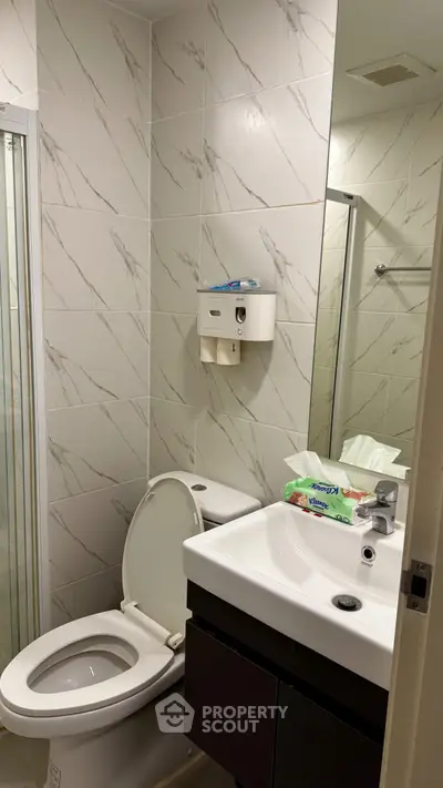 Modern bathroom with sleek fixtures and marble tile accents