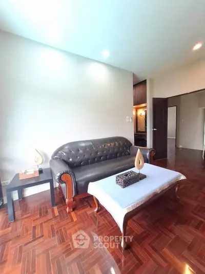Elegant living room with leather sofa and wooden flooring in modern apartment