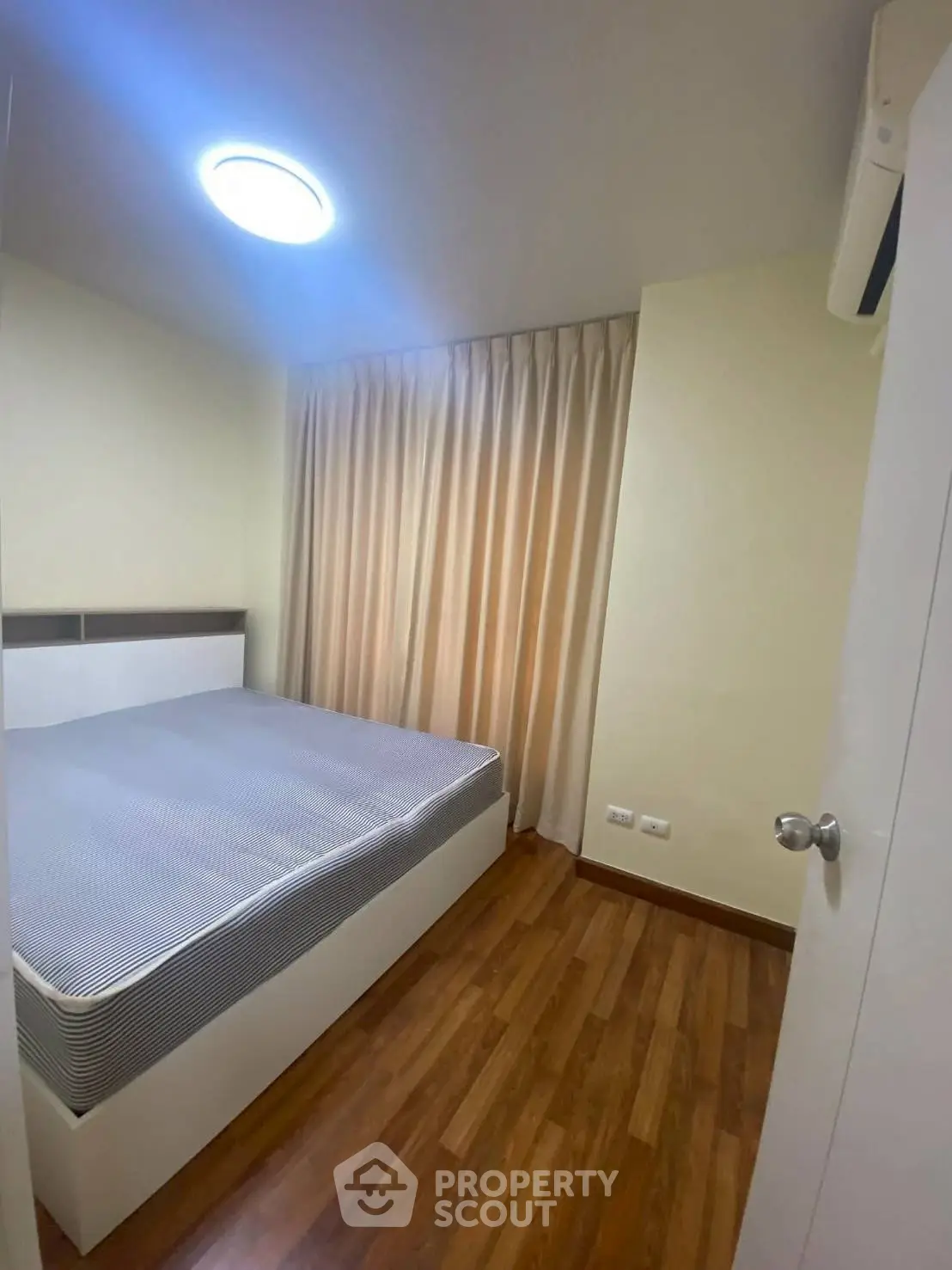 Cozy bedroom with wooden flooring and soft lighting