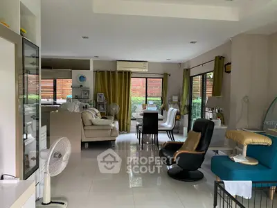 Spacious modern living room with elegant furniture and large windows offering garden views.