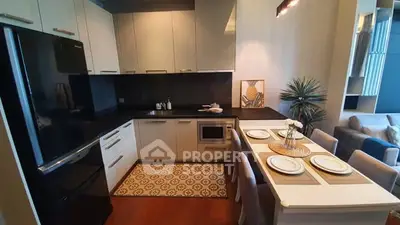 Modern kitchen with sleek black appliances and elegant dining area