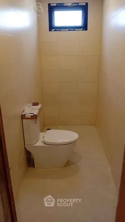 Compact bathroom with modern toilet and tiled walls, ideal for small spaces.