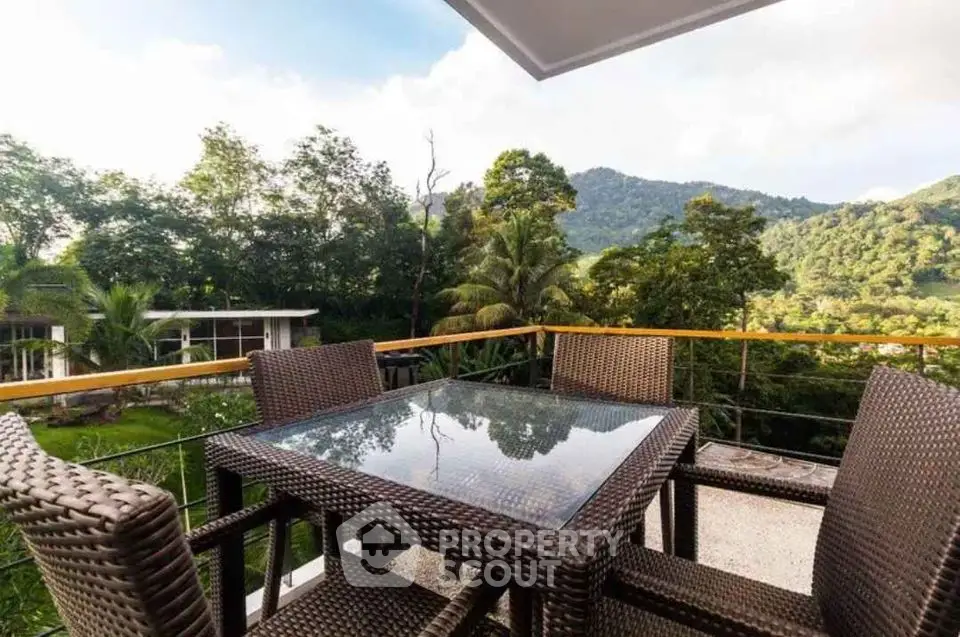 Stunning balcony with outdoor dining set and lush green mountain views.