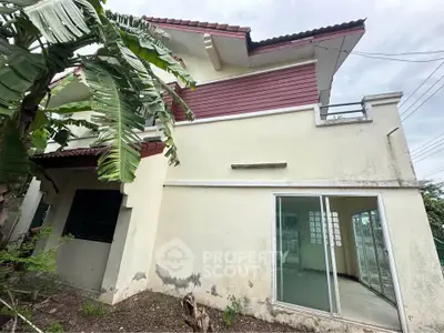 Charming two-story house with large windows and lush greenery, perfect for family living.
