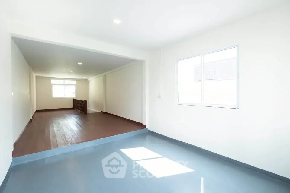 Spacious open-plan living area with abundant natural light and sleek flooring.