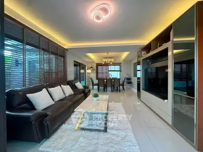 Luxurious living room with modern lighting and elegant dining area, perfect for entertaining guests.