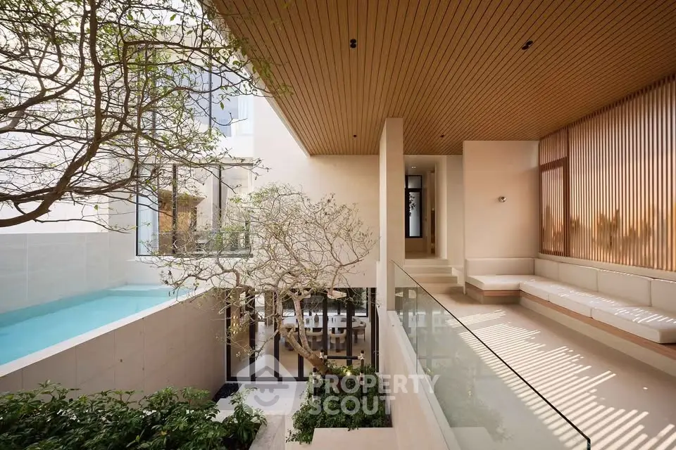 Luxurious modern home with pool and elegant wooden accents, featuring open spaces and lush greenery.