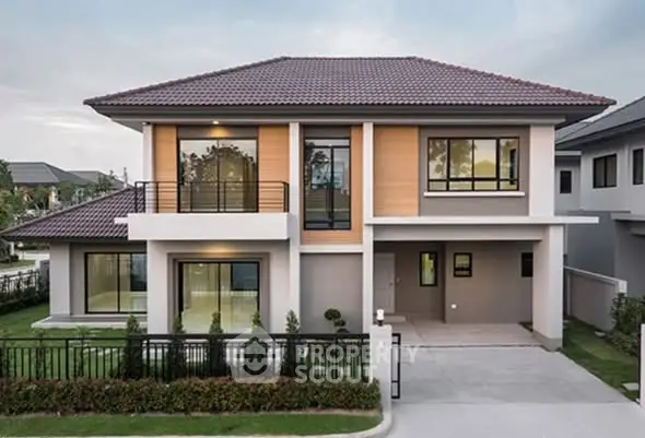 Modern two-story house with large windows and landscaped front yard in a suburban neighborhood.