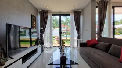 Spacious living room with modern decor and pool view, perfect for relaxation and entertainment.