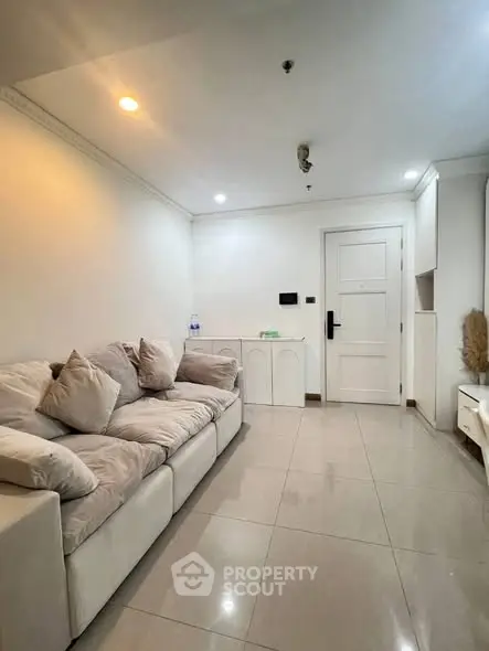 Spacious living room with modern white decor and cozy seating area.