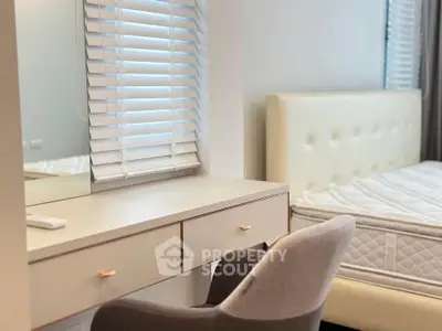Modern bedroom with stylish furniture and natural light, featuring a comfortable bed and elegant vanity.