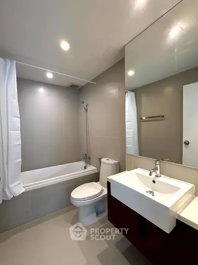 Modern bathroom with sleek fixtures and bathtub in a contemporary apartment.