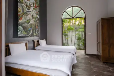 Charming bedroom with twin beds and garden view, featuring elegant decor and natural light.