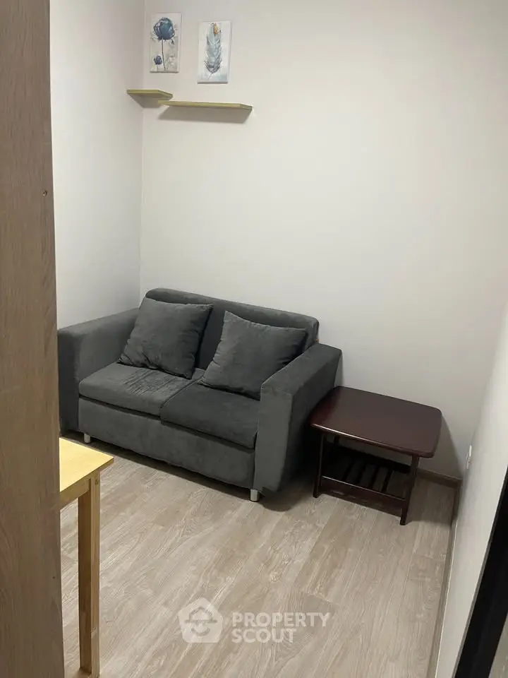 Cozy small living room with modern gray sofa and wooden side table, perfect for compact spaces.