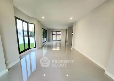 Spacious modern living room with large windows and glossy tile flooring