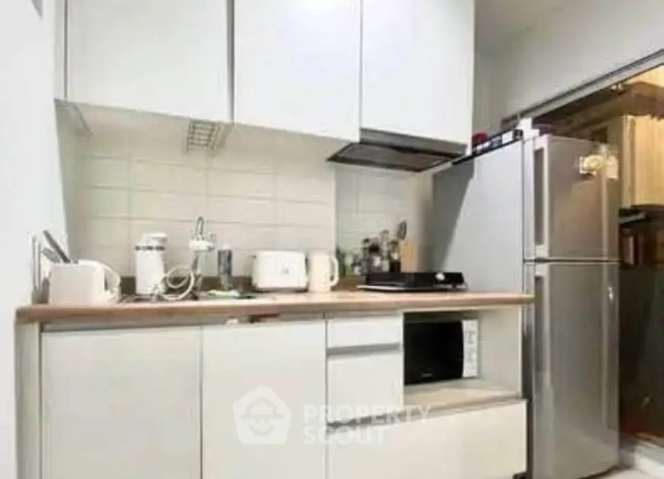 Modern kitchen with sleek white cabinets and stainless steel appliances