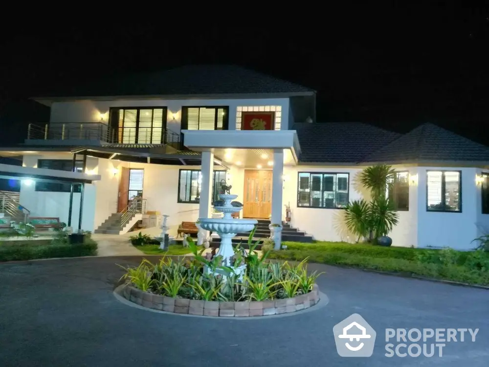 Stunning night view of a luxurious modern house with elegant lighting and landscaped driveway.