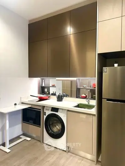 Modern kitchen with sleek cabinets, built-in oven, and washing machine