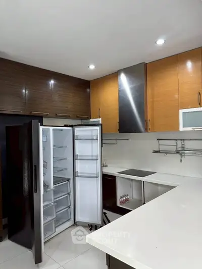 Modern kitchen with open fridge and sleek cabinetry