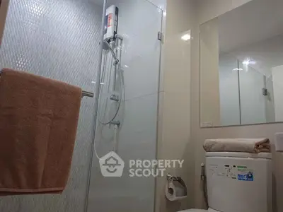 Modern bathroom with glass shower and sleek fixtures in contemporary apartment.