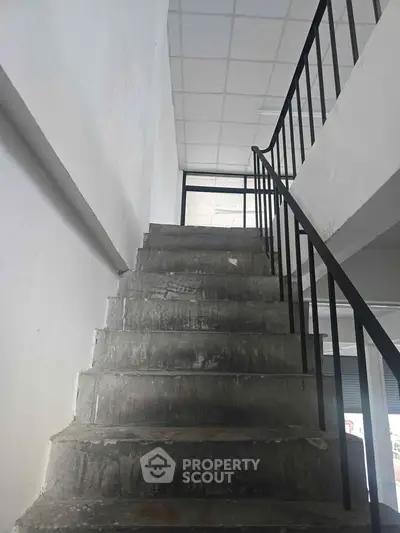 Industrial-style staircase with metal railing in commercial building