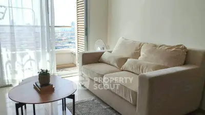 Cozy living room with beige sofa and balcony view in modern apartment