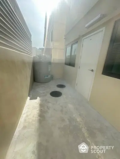 Modern exterior utility area with water tank and access door