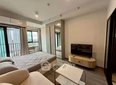 Modern bedroom with city view, featuring sleek furniture and large windows.