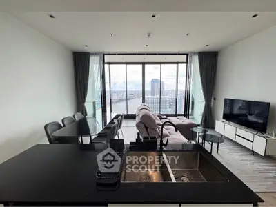 Luxurious living room with stunning city view, modern furniture, and open kitchen layout in high-rise apartment.