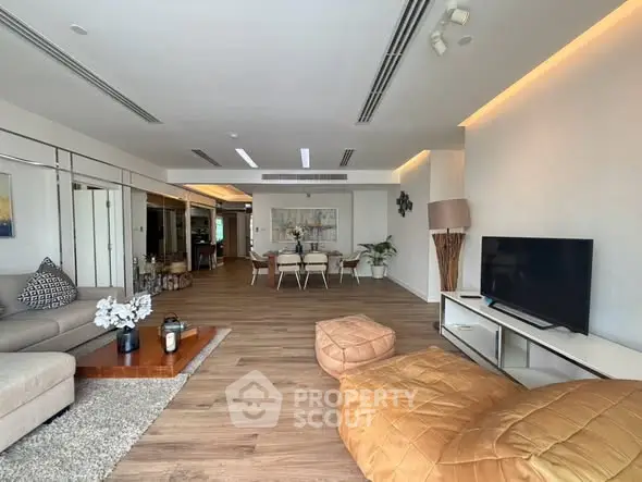Spacious modern living room with elegant decor and open layout, featuring cozy seating and stylish dining area.
