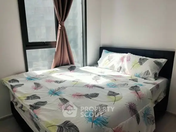 Cozy bedroom with modern decor and large window for natural light.