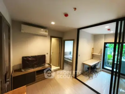 Modern apartment interior with open living area and bedroom, featuring sleek design and natural light.