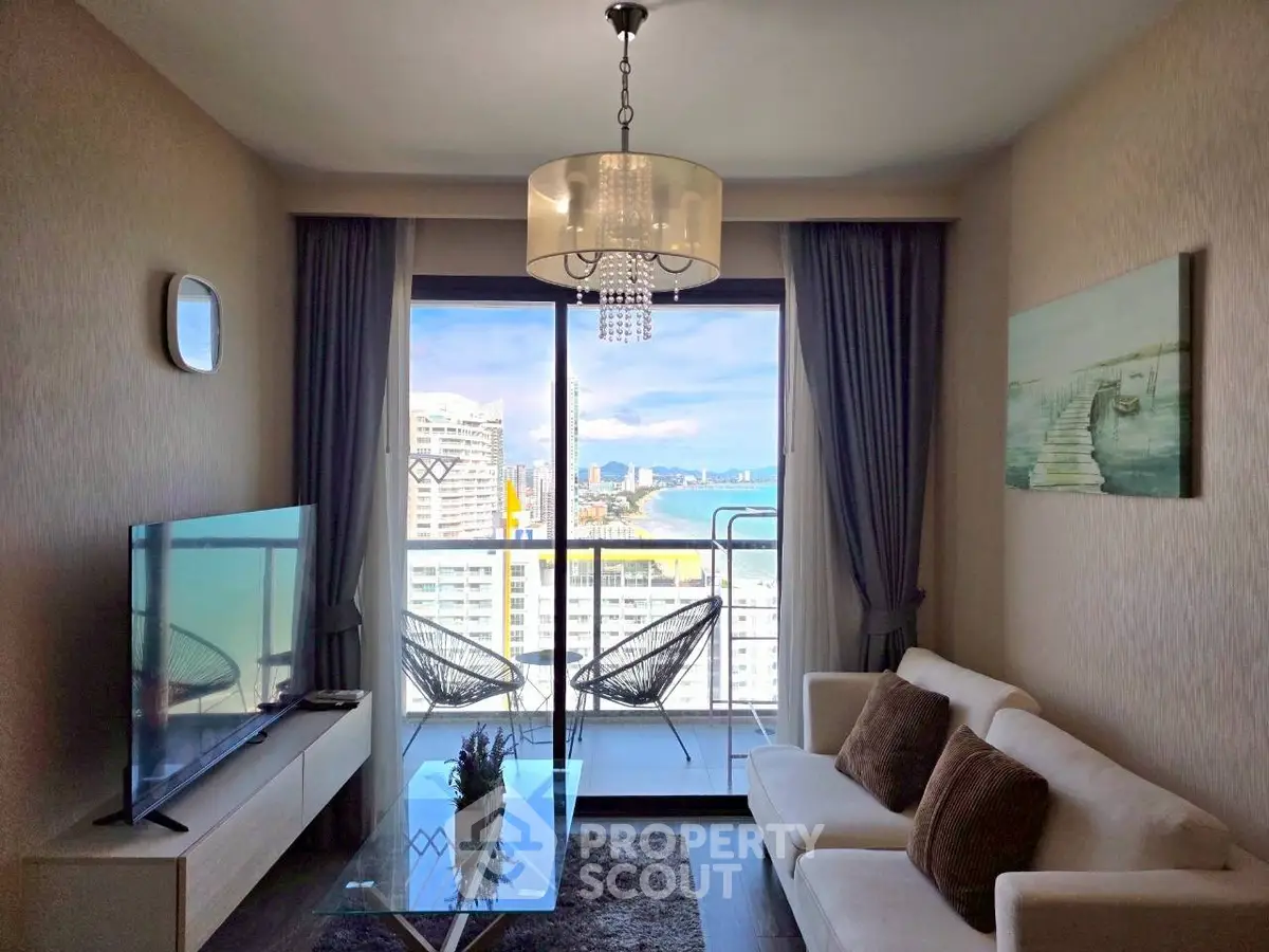 Modern living room with balcony and stunning city view, featuring elegant decor and large TV.