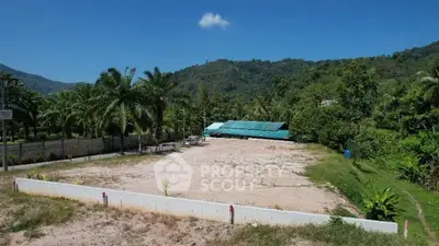 Expansive vacant land with lush greenery and mountain views, ideal for development opportunities.