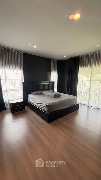 Spacious modern bedroom with large windows and elegant decor