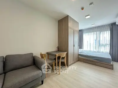 Modern studio apartment with cozy living area and large window view