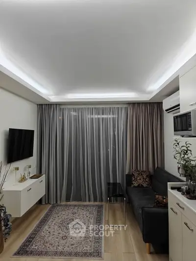 Modern living room with sleek design, featuring a cozy sofa, wall-mounted TV, and elegant lighting.