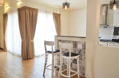 Bright open-concept kitchen with breakfast bar and elegant curtains.