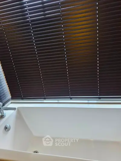 Modern bathroom with sleek bathtub and stylish blinds, perfect for relaxation and privacy.
