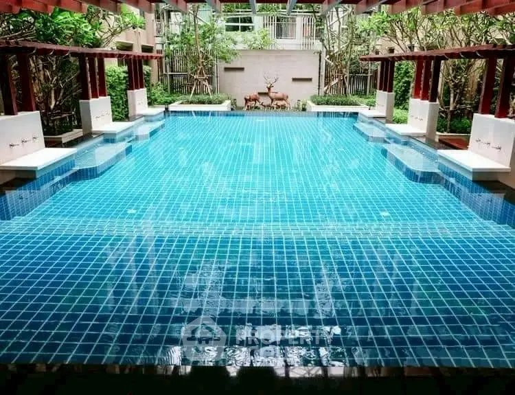 Luxurious swimming pool with elegant design and lush greenery, perfect for relaxation and leisure.
