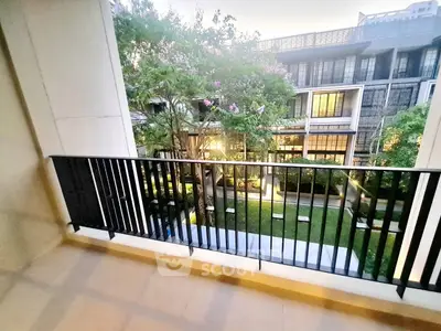 Spacious balcony with serene garden view in modern apartment complex