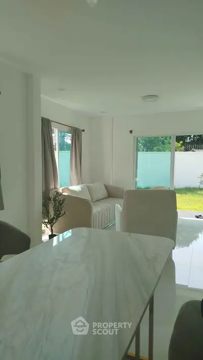 Bright modern living room with large windows and garden view
