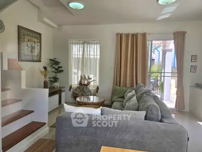 Charming living room with cozy gray sofa and natural light, perfect for relaxation.