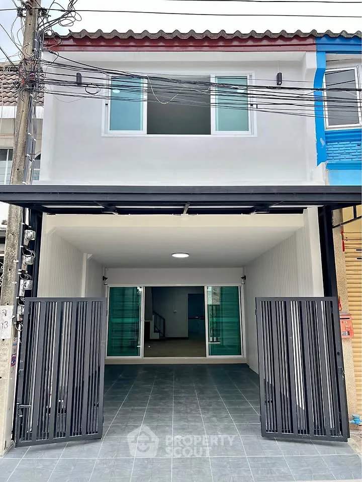 Modern townhouse exterior with gated entrance and spacious garage area, ideal for urban living.