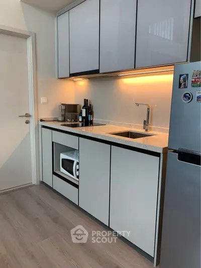 Modern kitchen with sleek cabinetry and built-in microwave