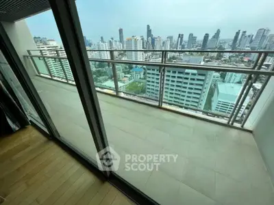 Spacious balcony with stunning city skyline view in modern high-rise apartment.